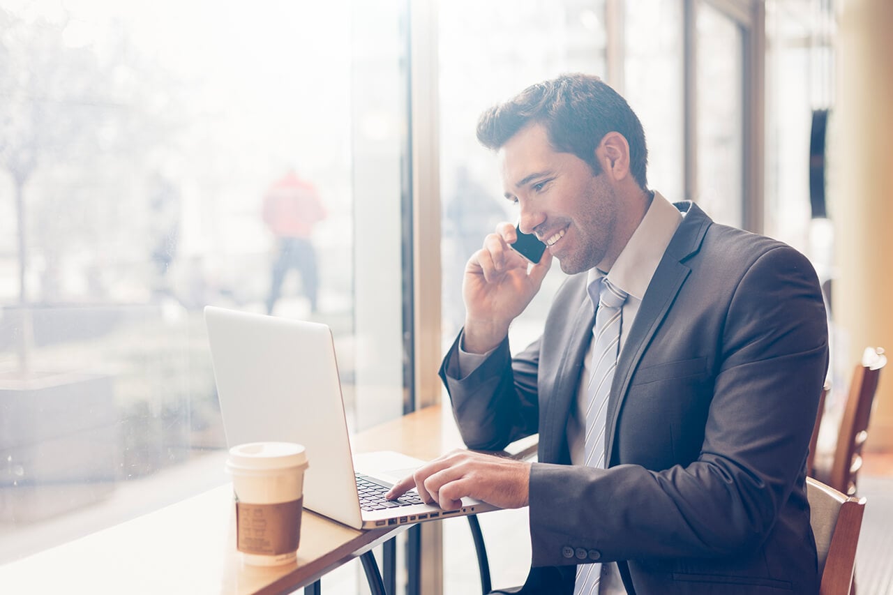 a man working on a laptop in a coffee shop