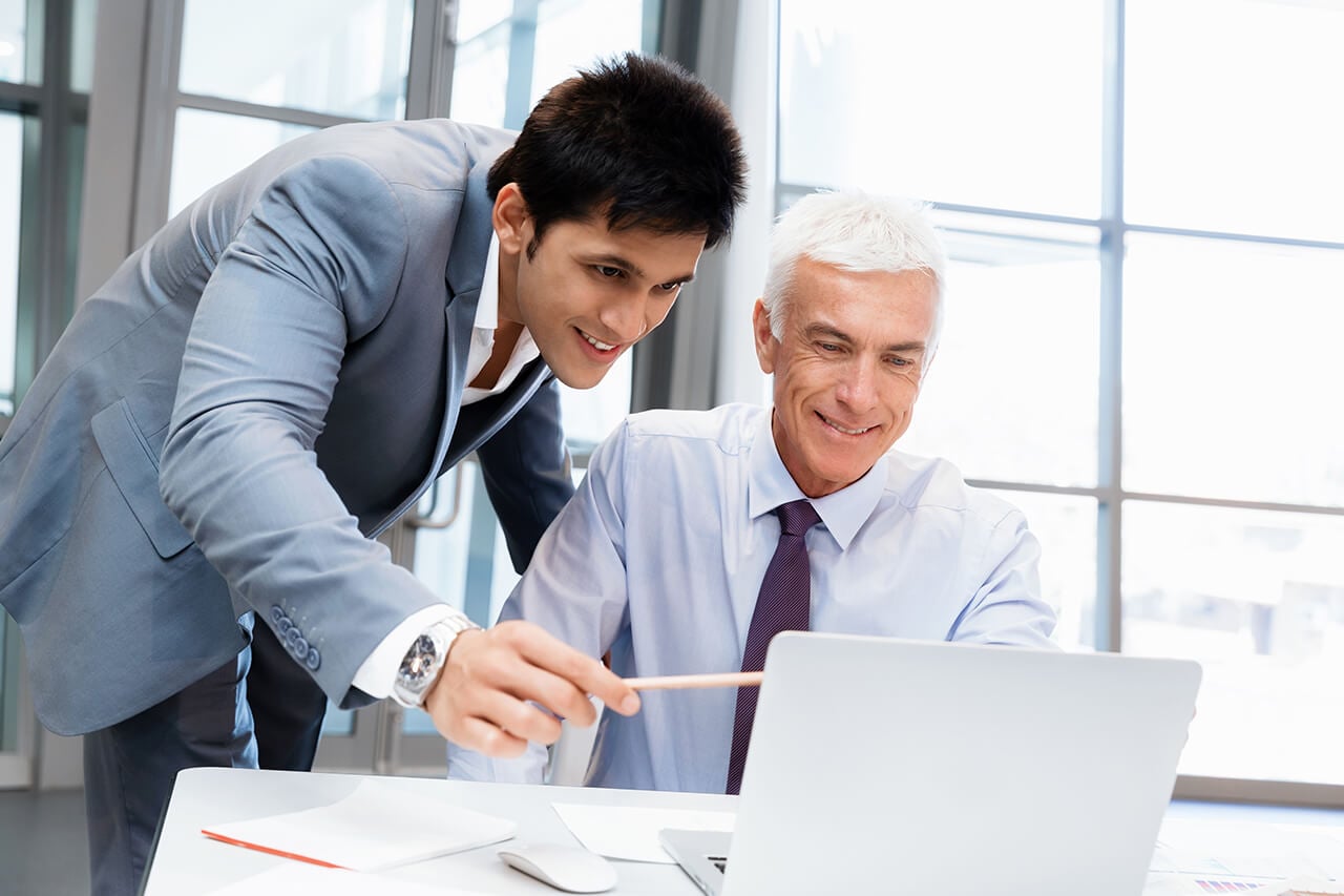 two men staring at a monitor